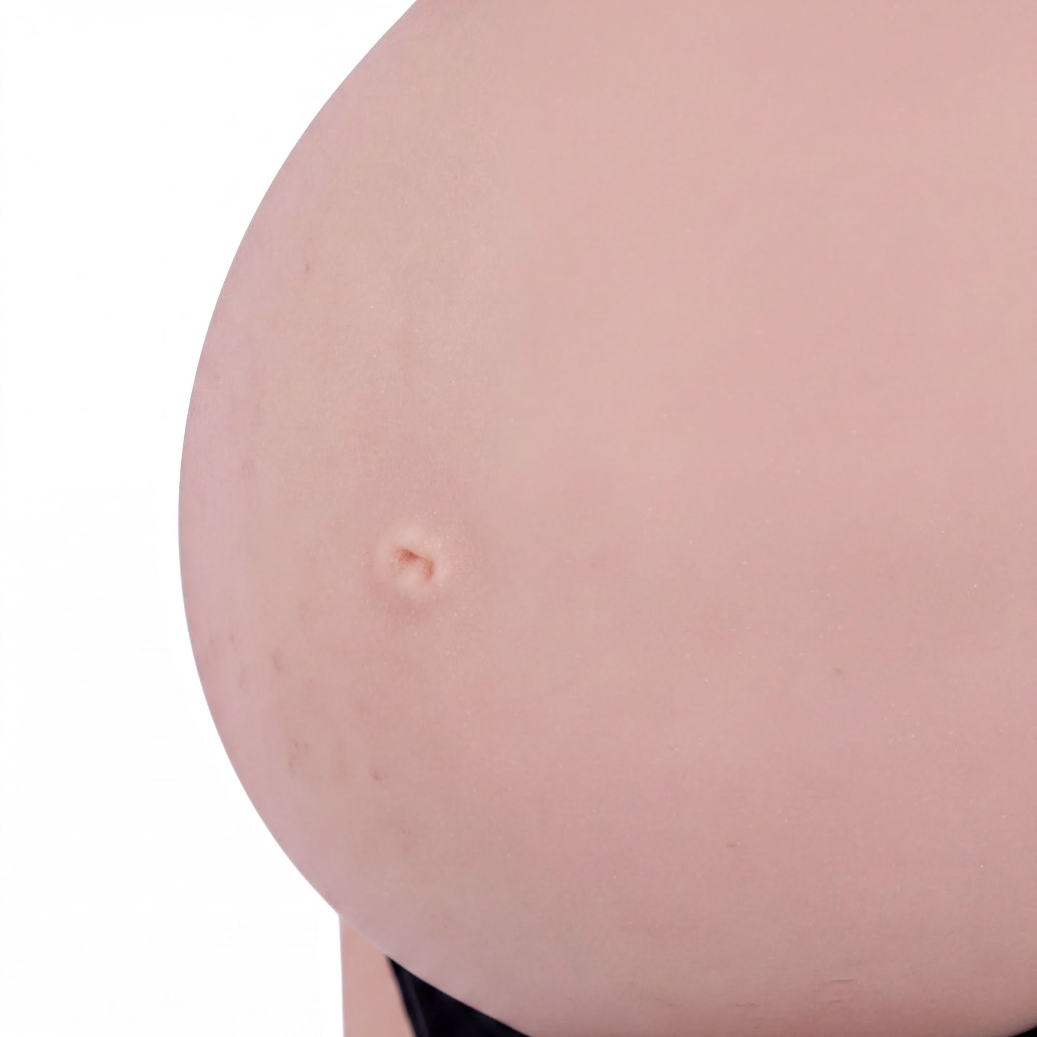 A close-up image of a person's belly, showing a small, circular mark or bump on the skin.