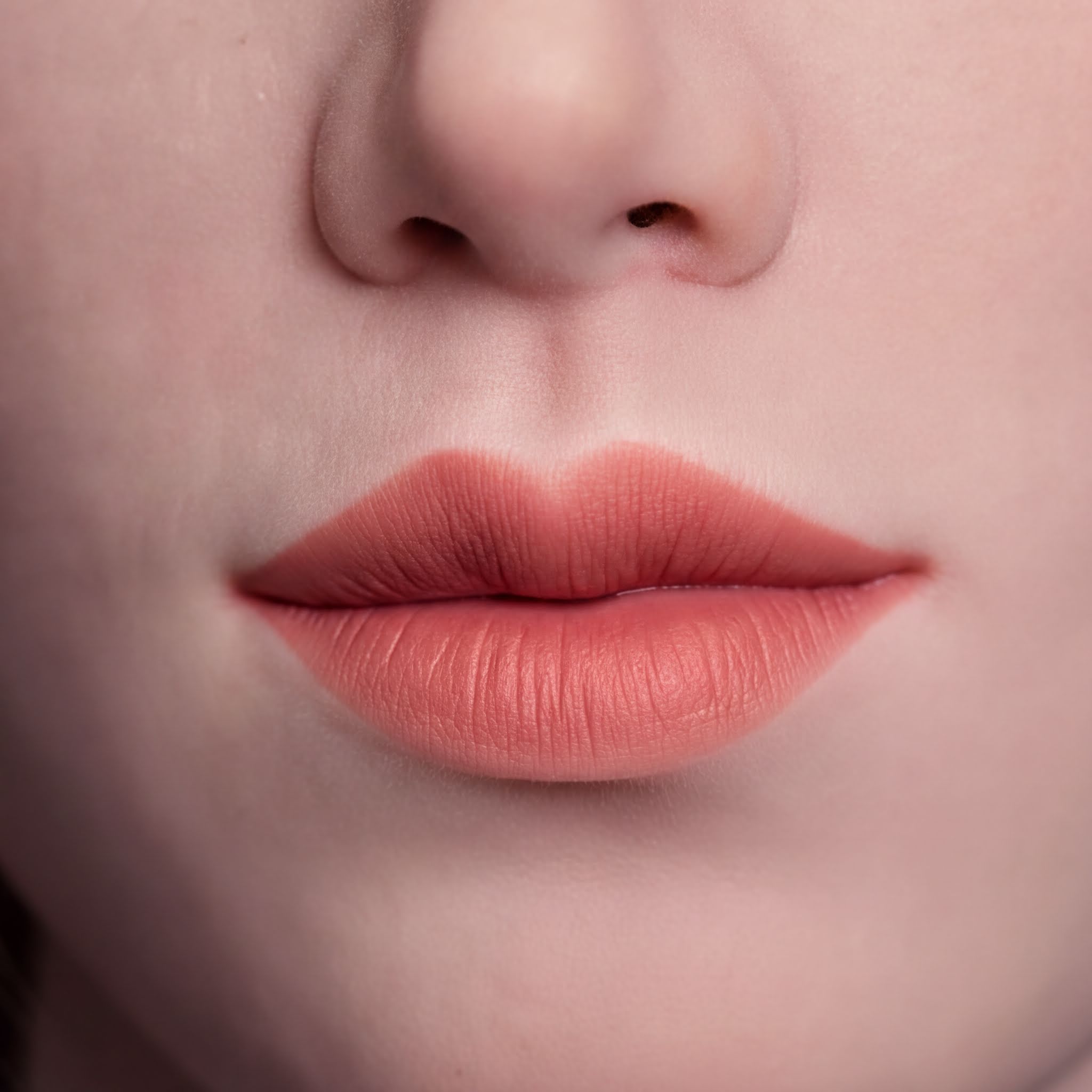 A close-up of a person's lips with a bright red lipstick color.