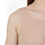 A close-up view of a woman's shoulder and neck area, showing a light pink tank top or sleeveless top.