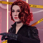 A close-up of a female figure wearing a black outfit and red wig, with caution tape in the background.