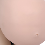 A close-up image of a person's belly, showing a small, round object or bump on the skin.
